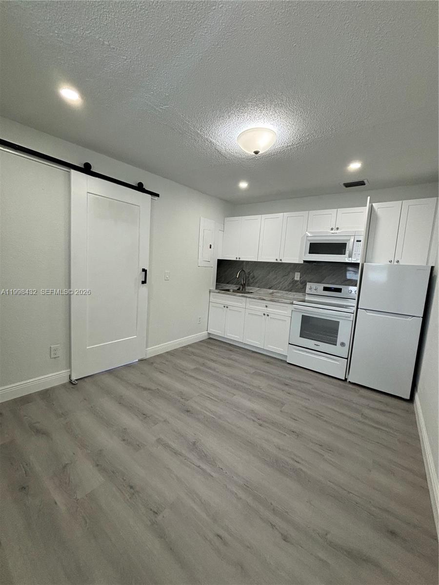 5011 Southwest 5th Street Miami, FL 33134 - Photo 2 of 5 a view of kitchen with stainless steel appliances wooden floor and electronic appliances