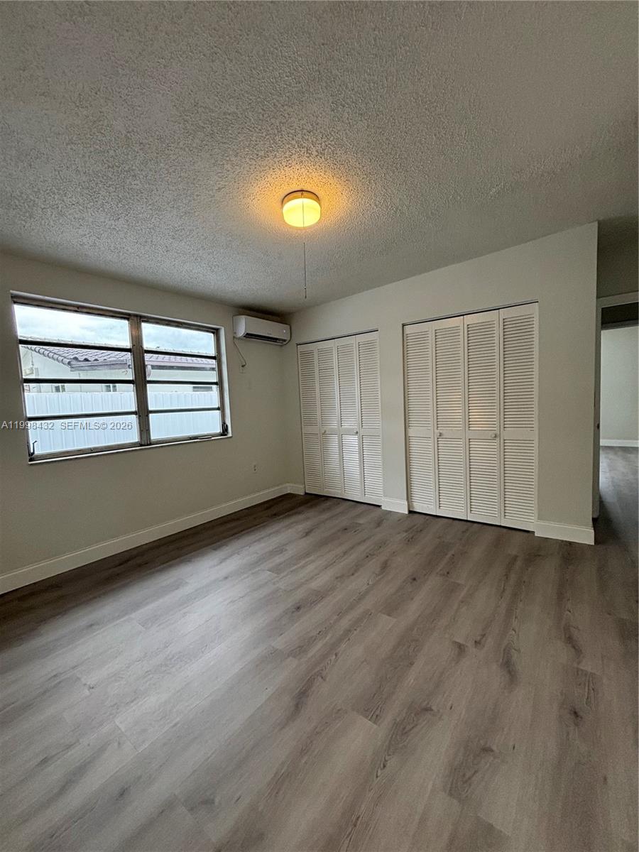 5011 Southwest 5th Street Miami, FL 33134 - Photo 5 of 5 a view of an empty room with a window and wooden floor