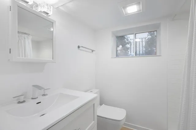 a bathroom with a sink a toilet and mirror