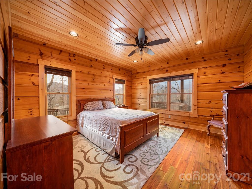 263 Mount Mitchell Drive Burnsville, NC 28714 - Photo 20 of 39 a spacious bedroom with a bed and wooden floors