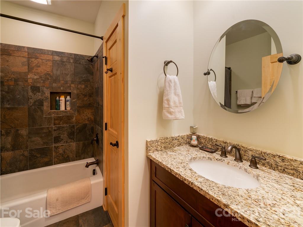 263 Mount Mitchell Drive Burnsville, NC 28714 - Photo 21 of 39 a bathroom with a granite countertop tub sink and mirror