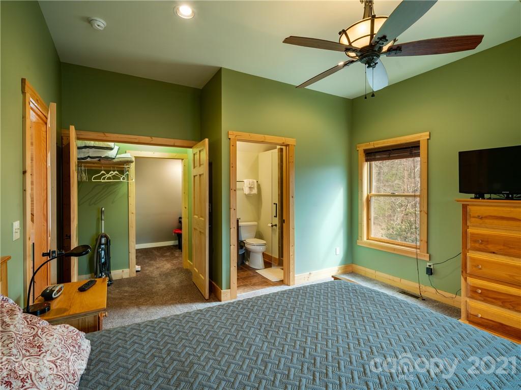 263 Mount Mitchell Drive Burnsville, NC 28714 - Photo 25 of 39 a bedroom with a bed and a chandelier