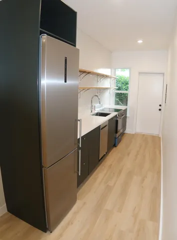 a kitchen with a refrigerator sink and cabinets