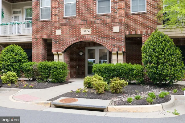 a front view of a house with a yard and potted plants