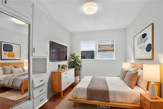 a bedroom with a large bed and a flat tv screen on dresser
