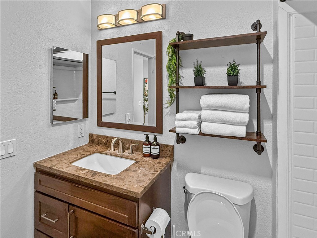 16955 Lake Knoll Parkway Riverside, CA 92503 - Photo 36 of 42 a bathroom with a toilet a sink and mirror