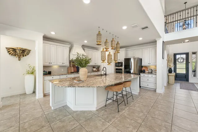 a kitchen with stainless steel appliances kitchen island granite countertop a sink and cabinets