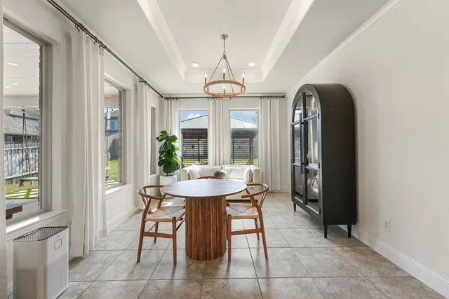 a dining room with furniture a chandelier and wooden floor