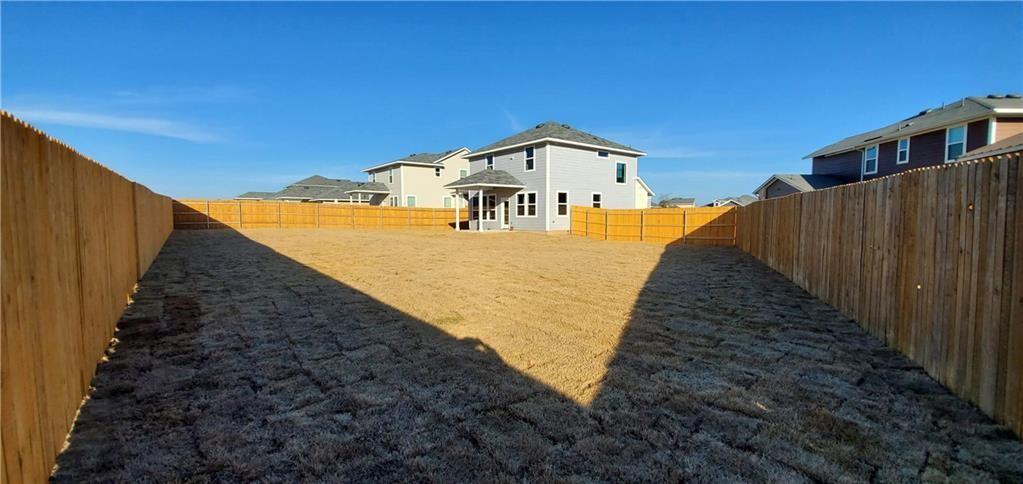 212 Lake Placid Run Elgin, TX 78621 - Photo 26 of 27 Expansive backyard featuring a new wood privacy fence, large grassy area, and rear exterior access