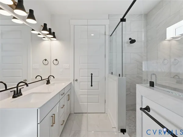 a bathroom with a double vanity sink a mirror and shower