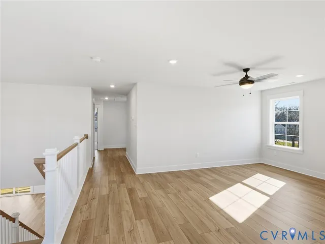 a view of a big room with wooden floor and windows