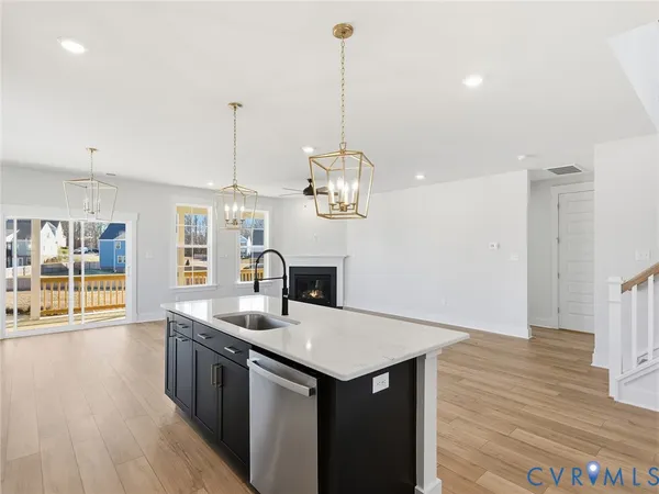 a kitchen with a sink a counter space and wooden floor