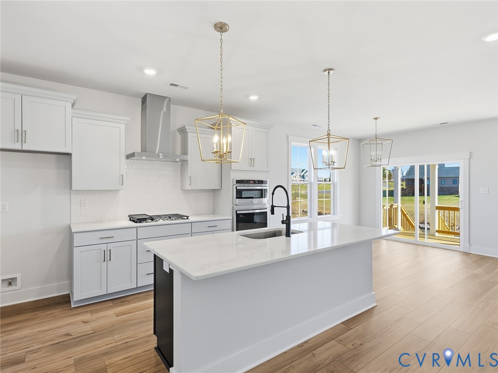 1711 Reed Marsh Lane Goochland, VA 23063 - Photo 4 of 25 a kitchen with stainless steel appliances granite countertop a sink a stove and a wooden floors