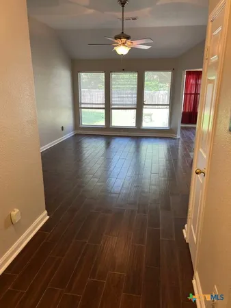 wooden floor in an empty room with a window