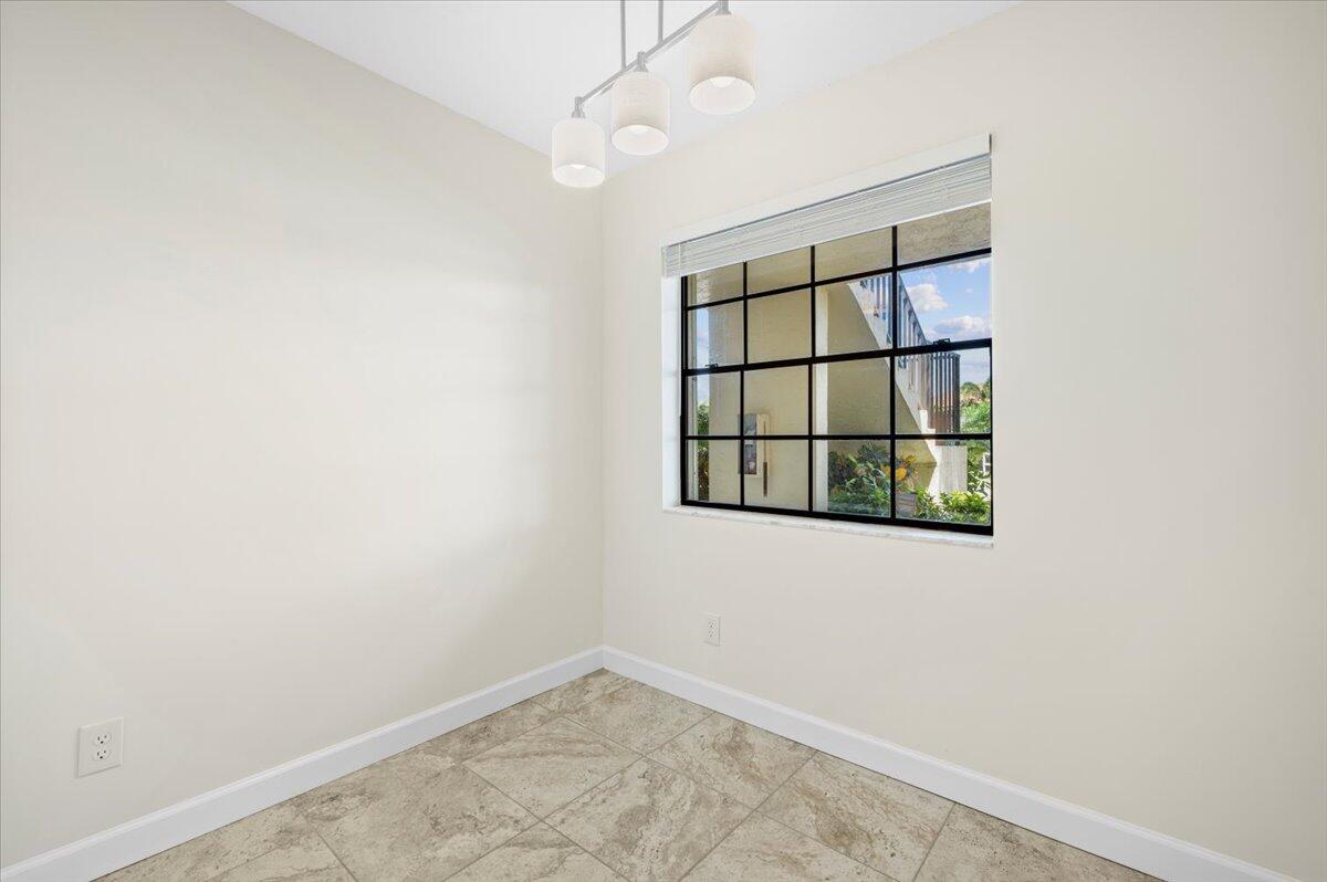 101 Pinecrest Circle, Unit A Jupiter, FL 33458 - Photo 10 of 25 an empty room with windows and fan