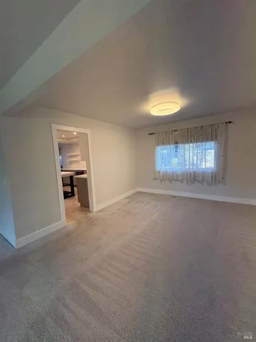 an empty room with windows and cabinet