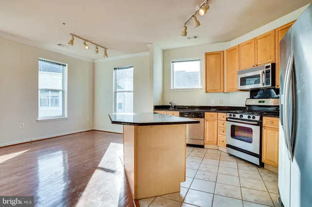 a kitchen with stainless steel appliances granite countertop a stove a microwave and a sink