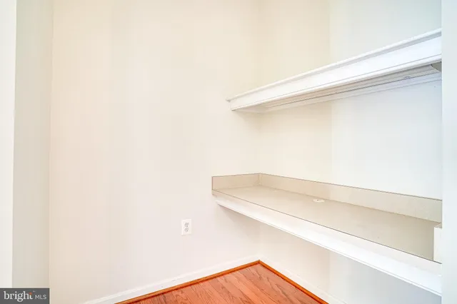 an empty room with chandelier fan and windows