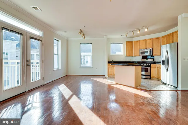 a kitchen with stainless steel appliances granite countertop a refrigerator a stove a sink and a microwave