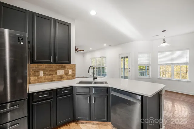a kitchen with granite countertop a stove sink and cabinets