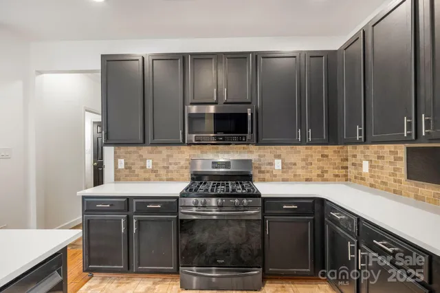 a large kitchen with stainless steel appliances kitchen island granite countertop a large counter top cabinets and stainless steel appliances