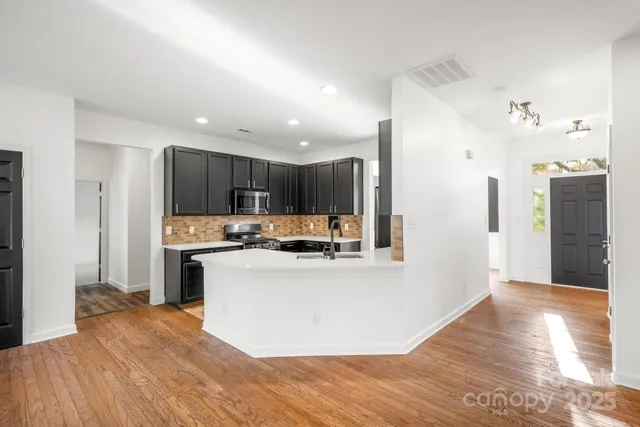 a view of a livingroom with a fireplace a ceiling fan and wooden floor