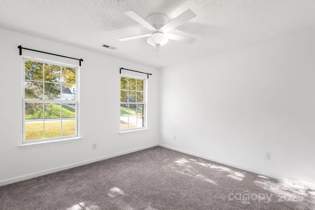 a view of a livingroom with a ceiling fan and window