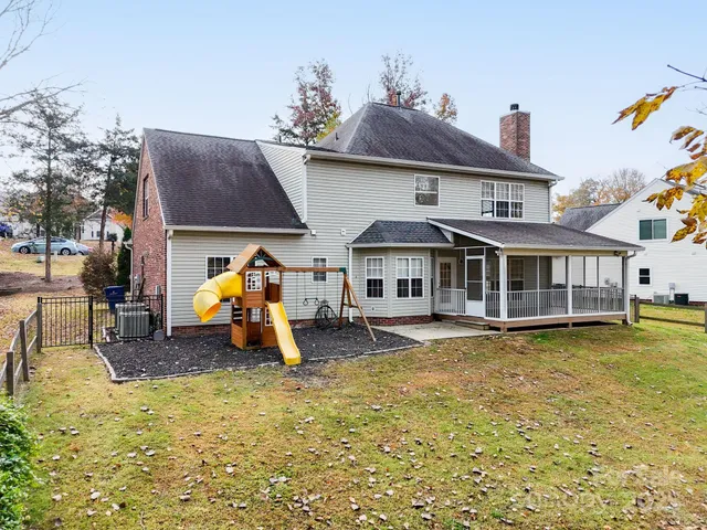 a front view of a house with swimming pool and furniture