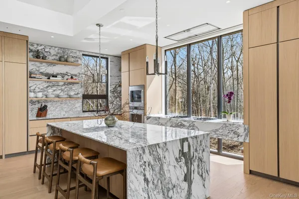 a kitchen with stainless steel appliances granite countertop a table chairs and a refrigerator