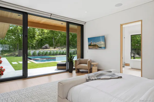 a bedroom with a bed and large windows