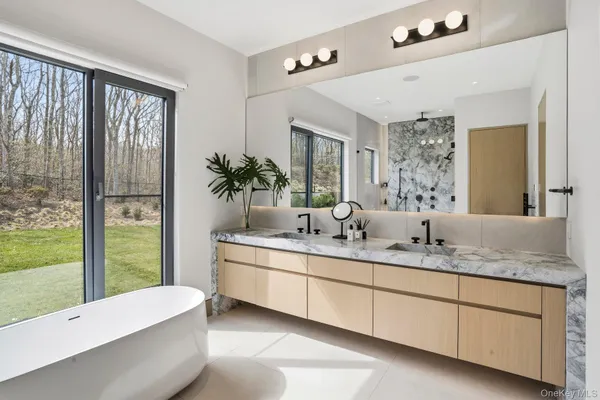 a bathroom with a granite countertop sink and a large mirror
