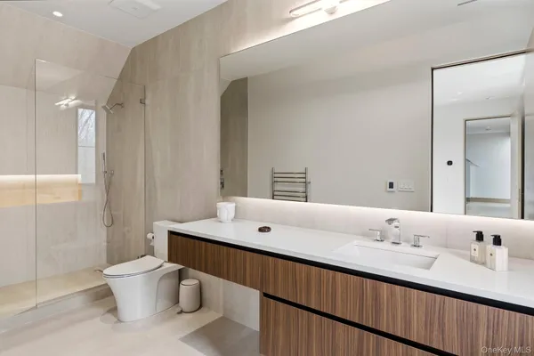 a bathroom with a double vanity sink toilet and a mirror
