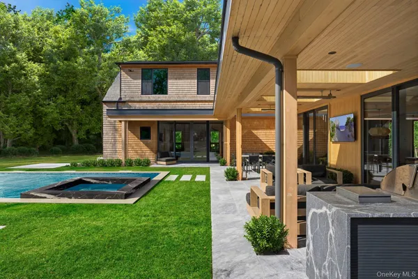 a front view of a house with swimming pool having outdoor seating