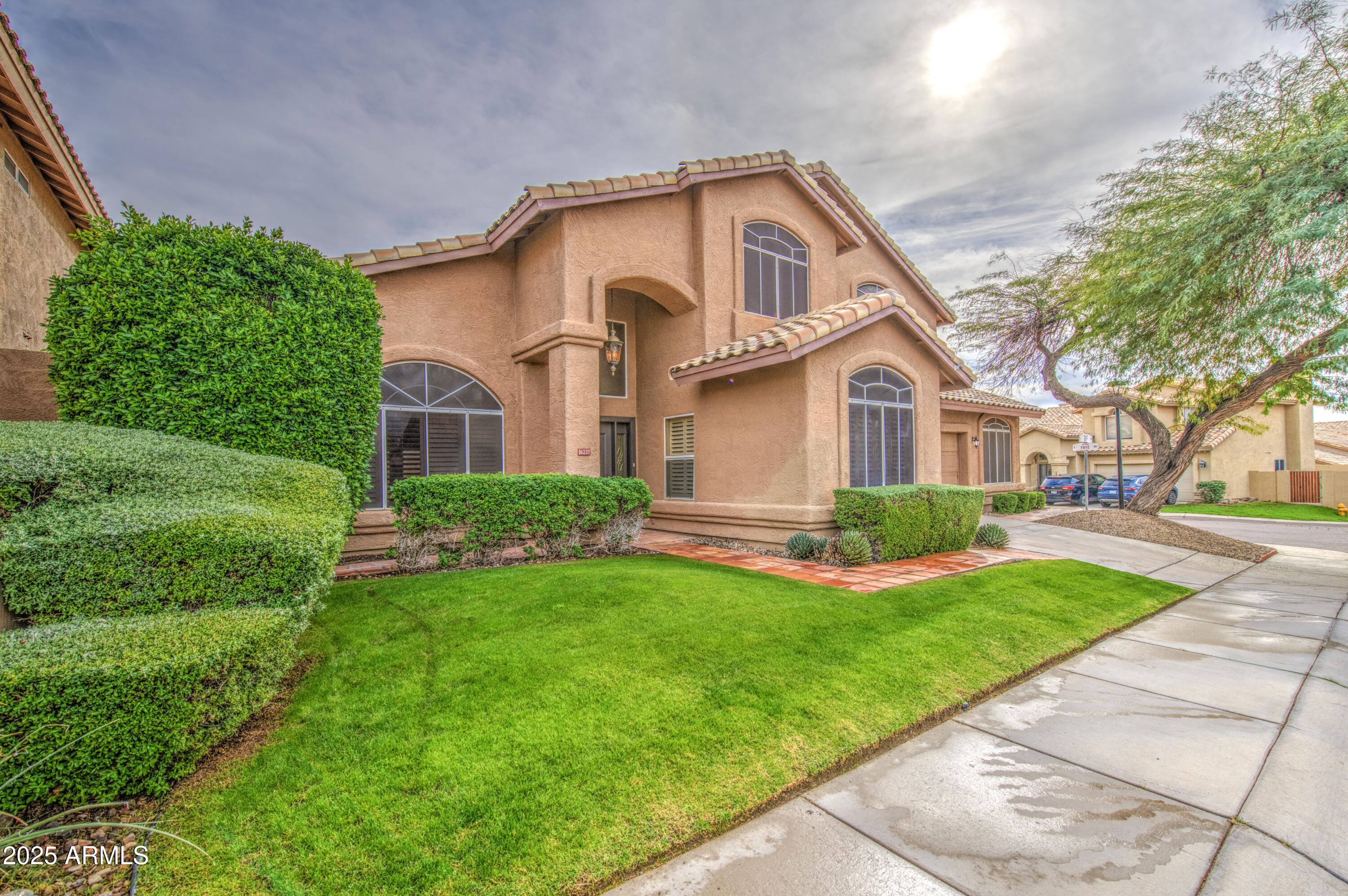 16237 South 13th Street Phoenix, AZ 85048 - Photo 2 of 68 a front view of a house with a yard and garage
