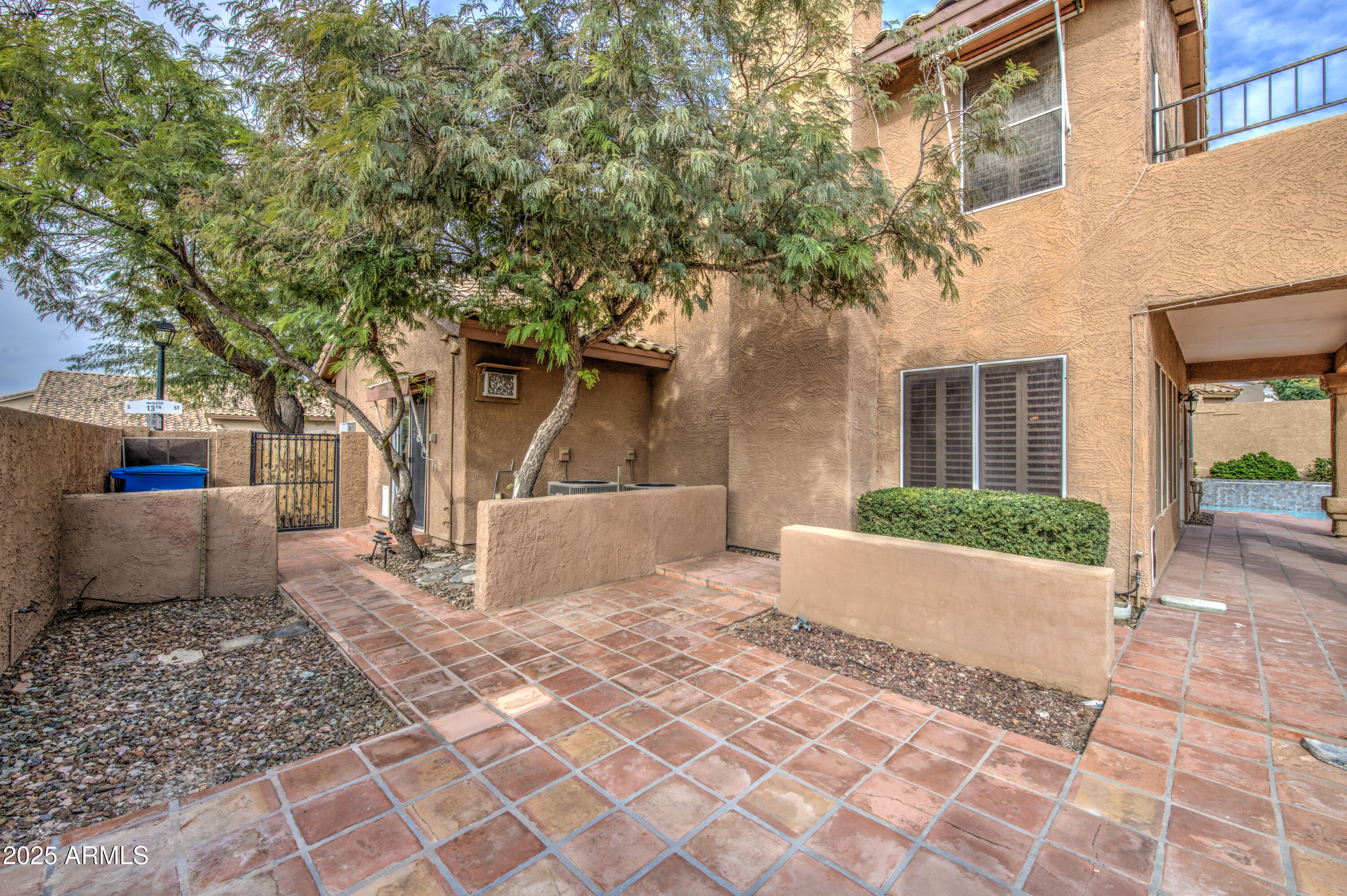 16237 South 13th Street Phoenix, AZ 85048 - Photo 57 of 68 a view of a white house with a large tree and plants