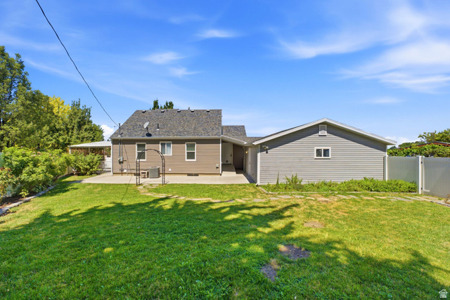 1925 South Main Street Bountiful, UT 84010 - Photo 33 of 48 Expansive green lawn with a concrete patio and a detached auxiliary building featuring siding
