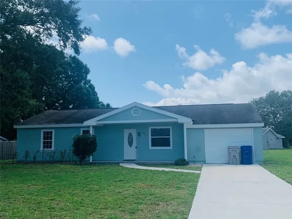 a front view of a house with a garden and yard