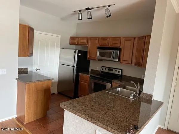 a kitchen with granite countertop a stove cabinets and microwave