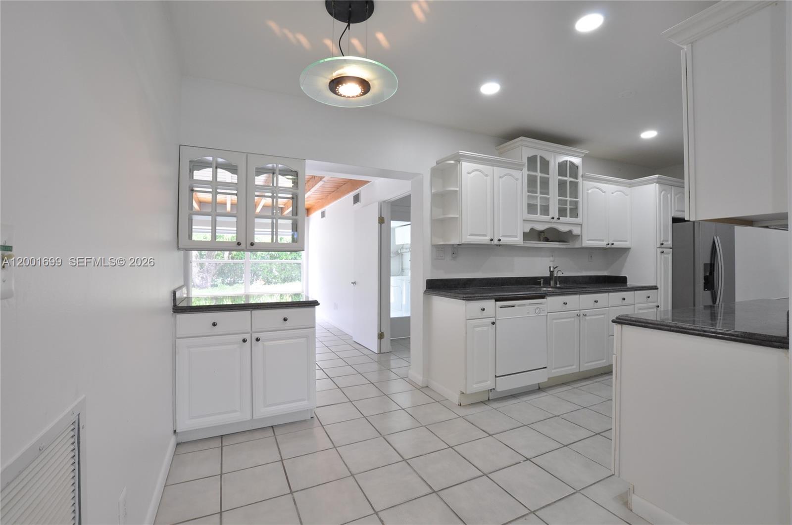 11111 Southwest 78th Court Pinecrest, FL 33156 - Photo 7 of 19 a kitchen with white cabinets and window