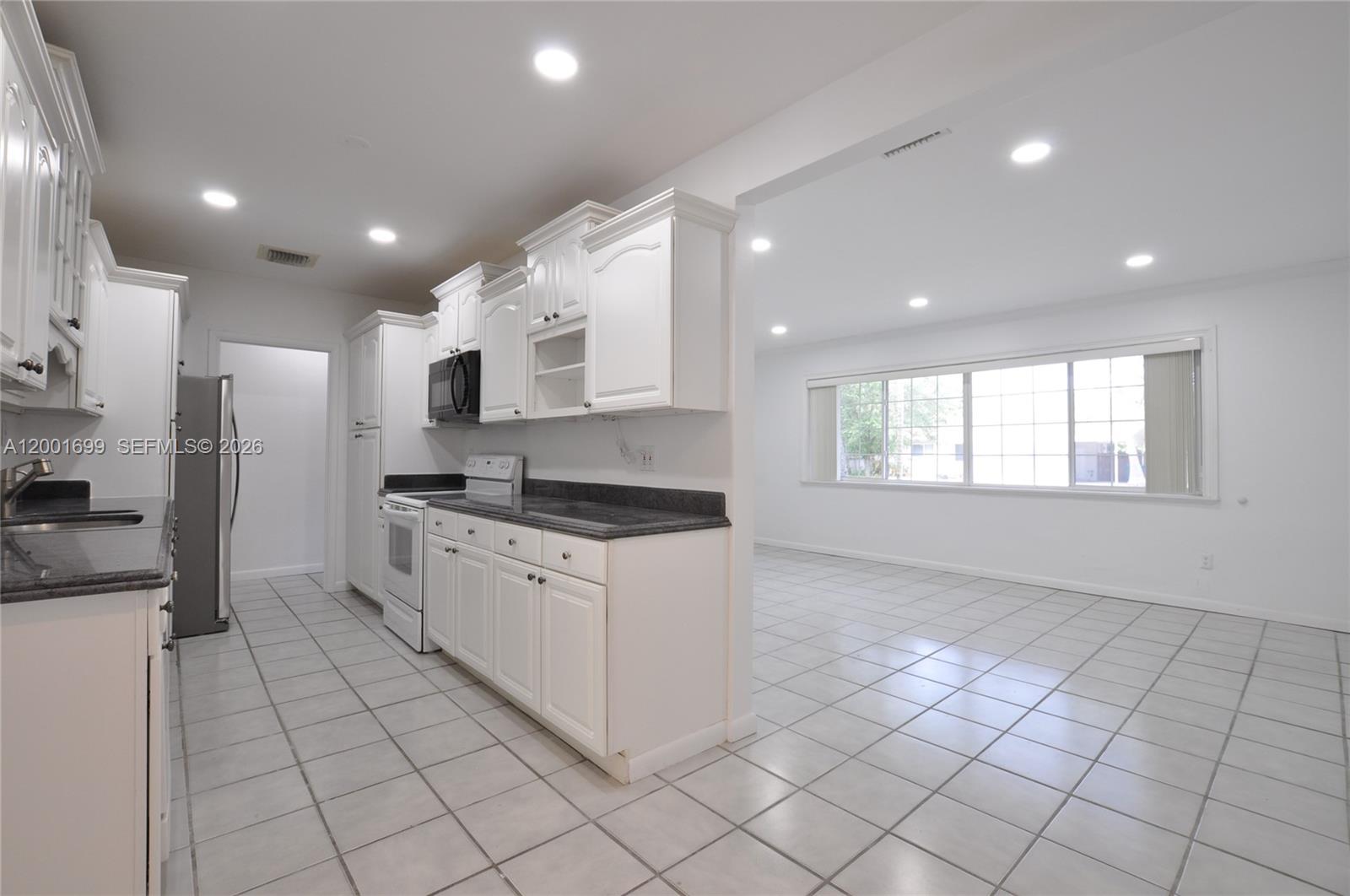 11111 Southwest 78th Court Pinecrest, FL 33156 - Photo 8 of 19 a large kitchen with stainless steel appliances granite countertop a large stove top oven and cabinets