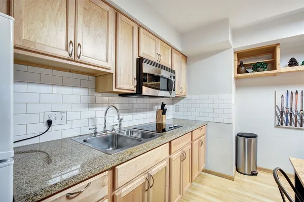 a kitchen with stainless steel appliances granite countertop a sink stove and microwave