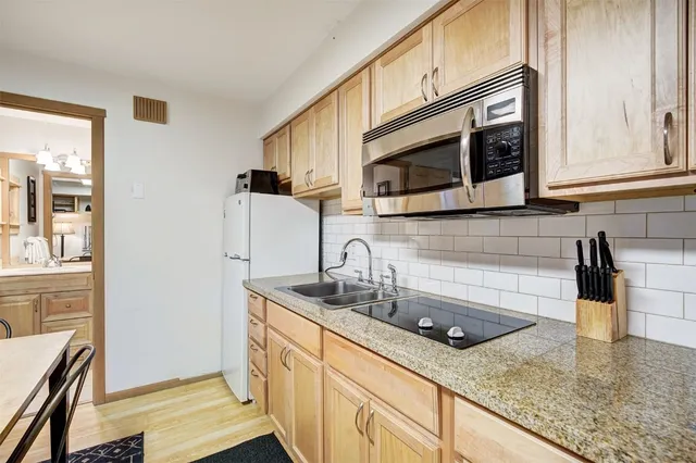 a kitchen with stainless steel appliances granite countertop a sink stove and microwave
