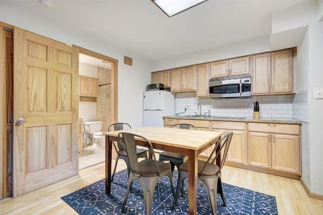 a kitchen with stainless steel appliances granite countertop a stove a sink a microwave and a refrigerator