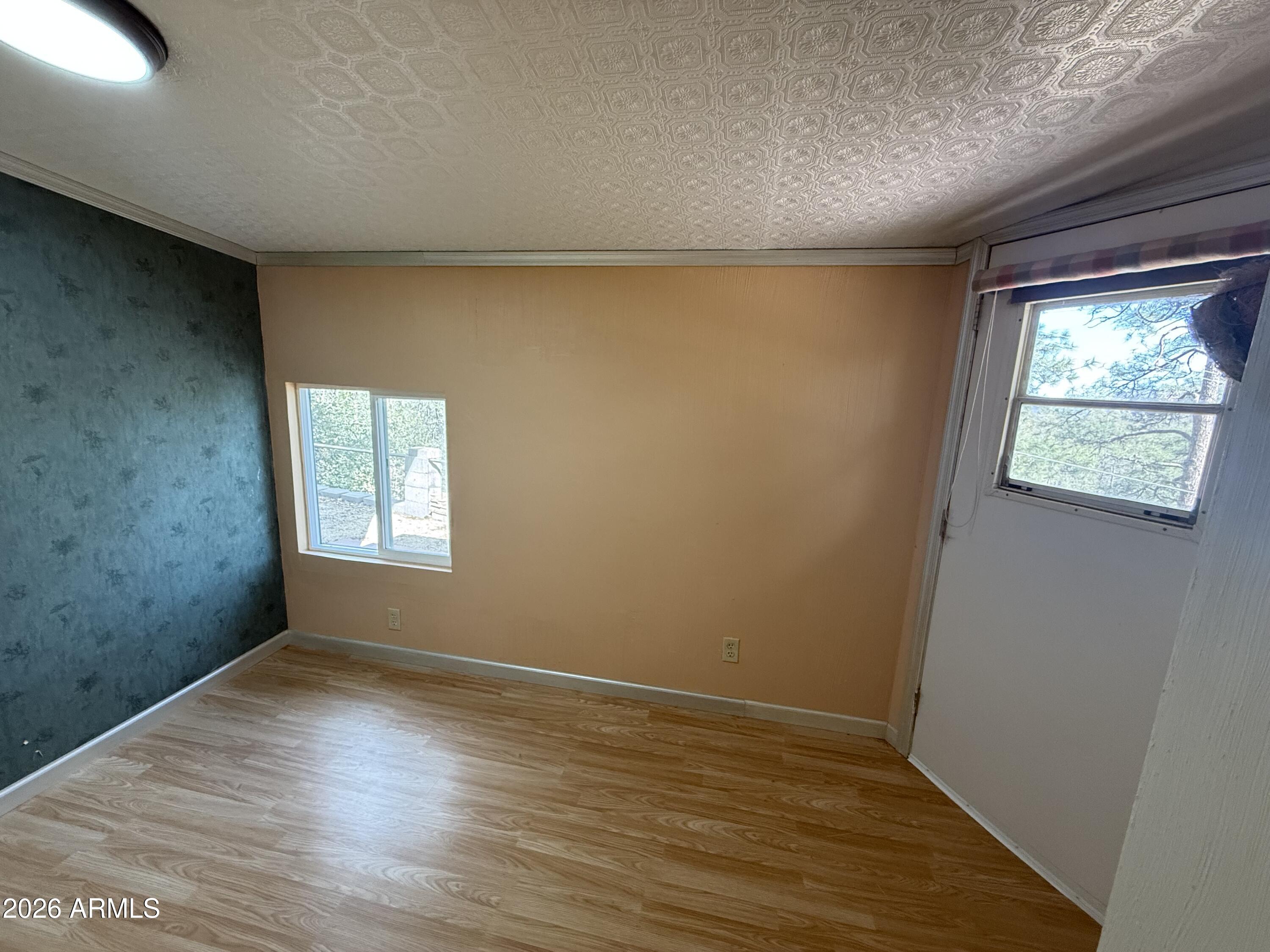 23338 Sunny South Road Crown King, AZ 86343 - Photo 14 of 32 an empty room with wooden floor and windows
