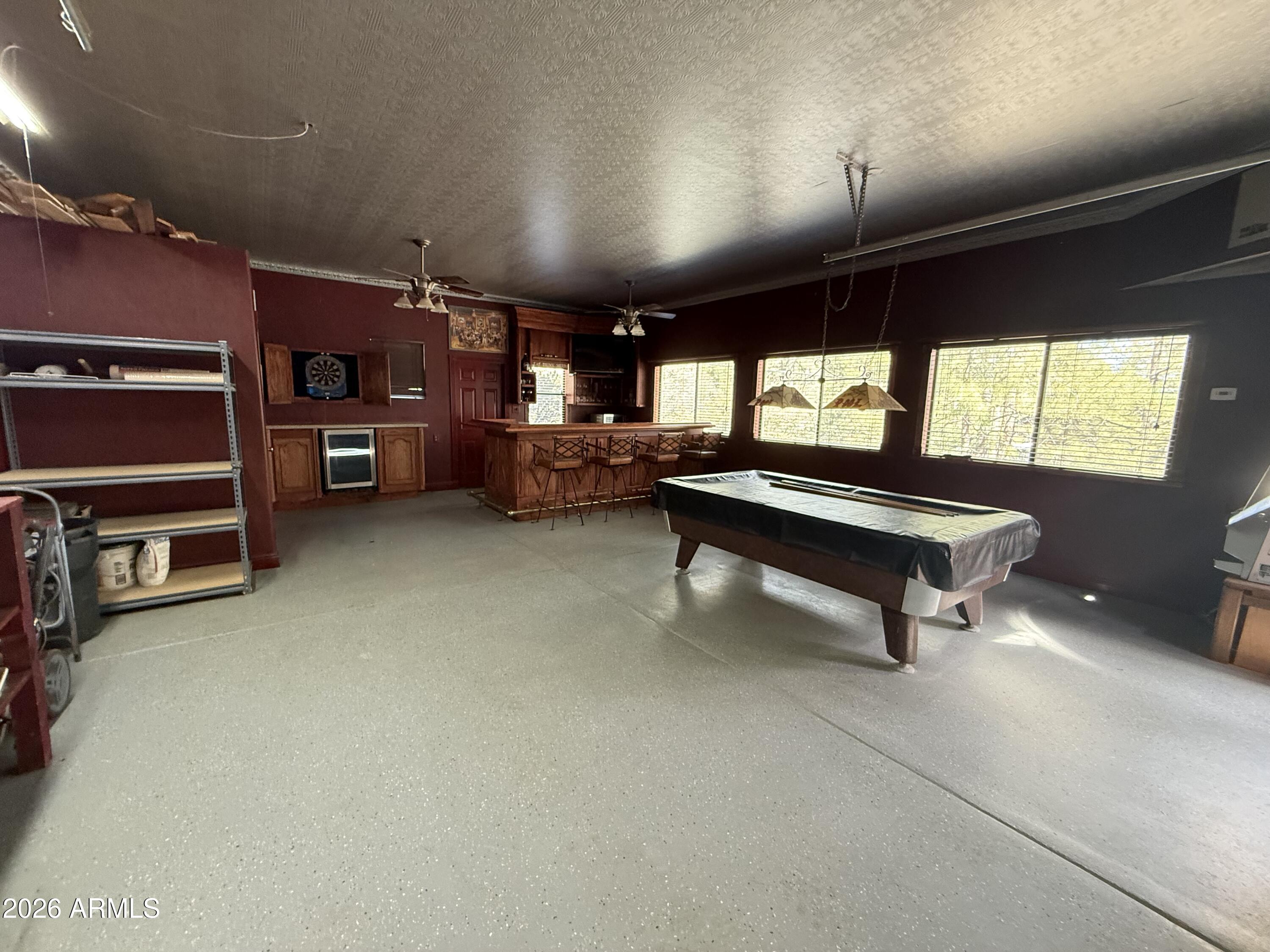 23338 Sunny South Road Crown King, AZ 86343 - Photo 20 of 32 a living room with furniture a pool table gym equipment and a large window
