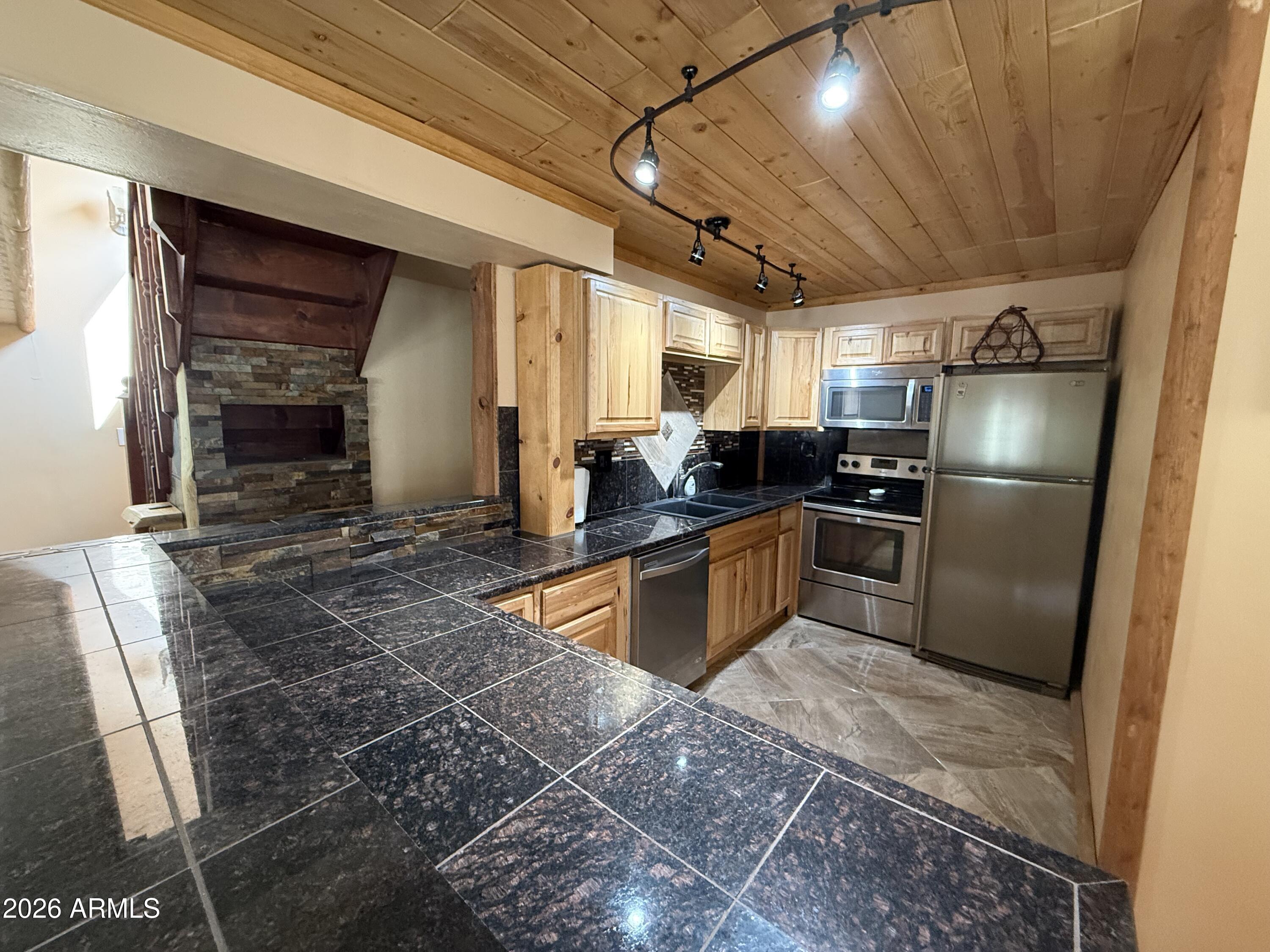23338 Sunny South Road Crown King, AZ 86343 - Photo 9 of 32 a kitchen with granite countertop a sink stainless steel appliances and cabinets