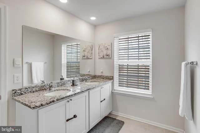 a bathroom with a granite countertop sink a toilet and a bathtub