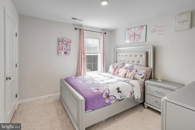 a bedroom with a bed wooden floor and a window