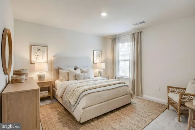 a bedroom with a large bed and a potted plant