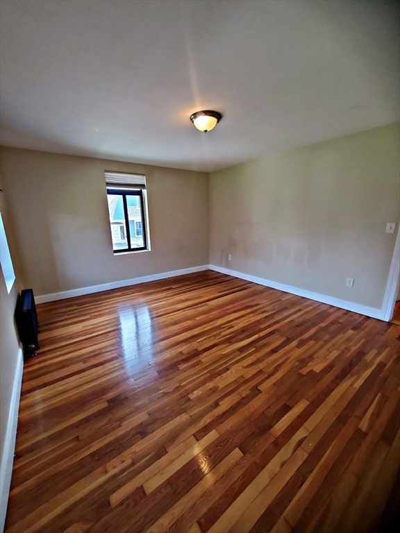 8 Ashland Street, Unit 1L Worcester, MA 01609 - Photo 22 of 27 a view of empty room with window and wooden floor